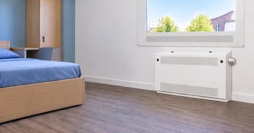 Mental health bedroom with an anti-ligature radiator guard beneath an uninterrupted window view
