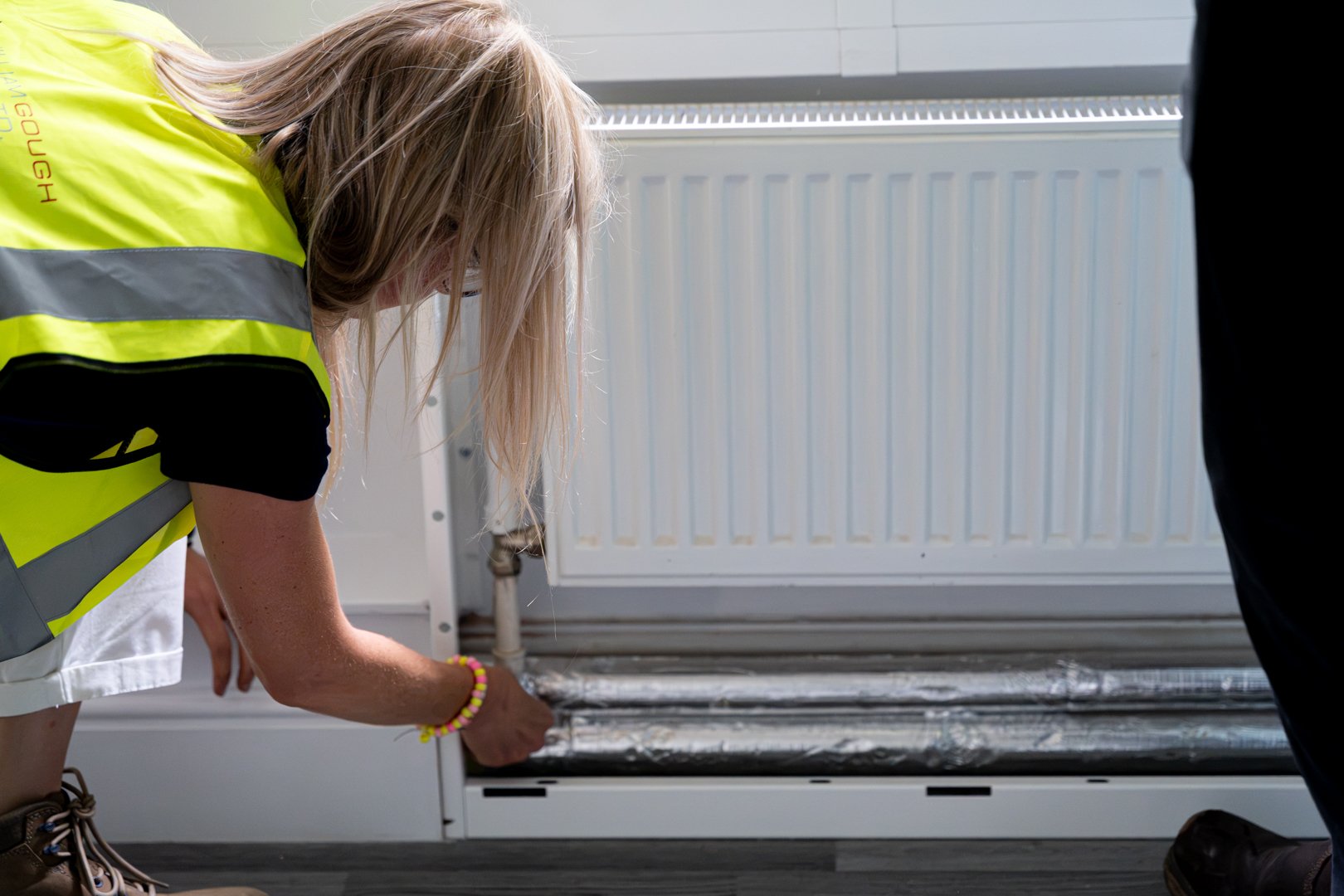 worker reviewing piping through opened casing